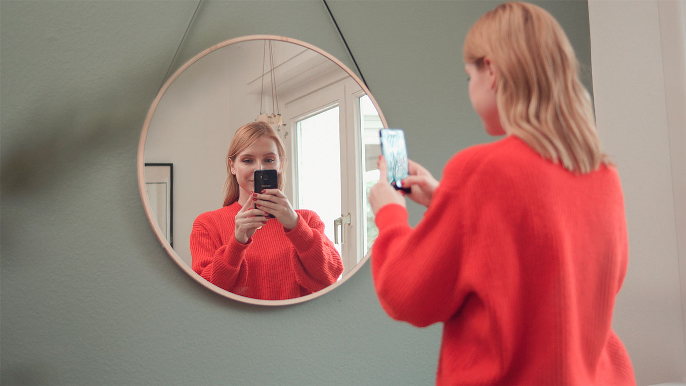 Standbild aus einer Werbespot Produktion für Samsung. Eine Frau fotografiert sich im Spiegel.